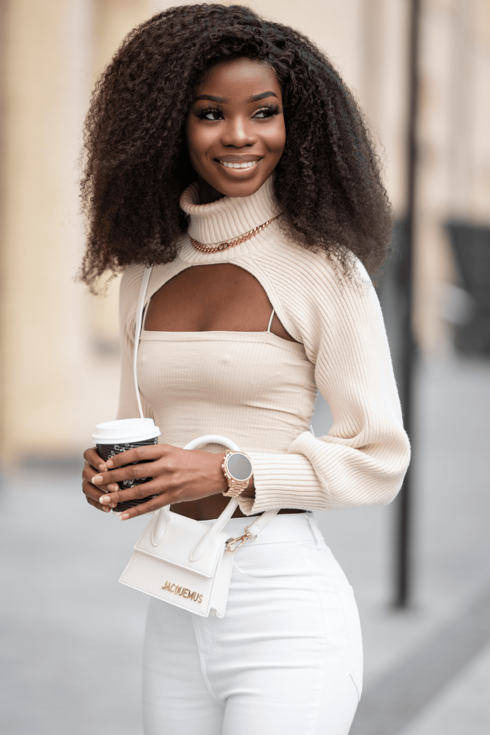 model smiling, wearing a beige top